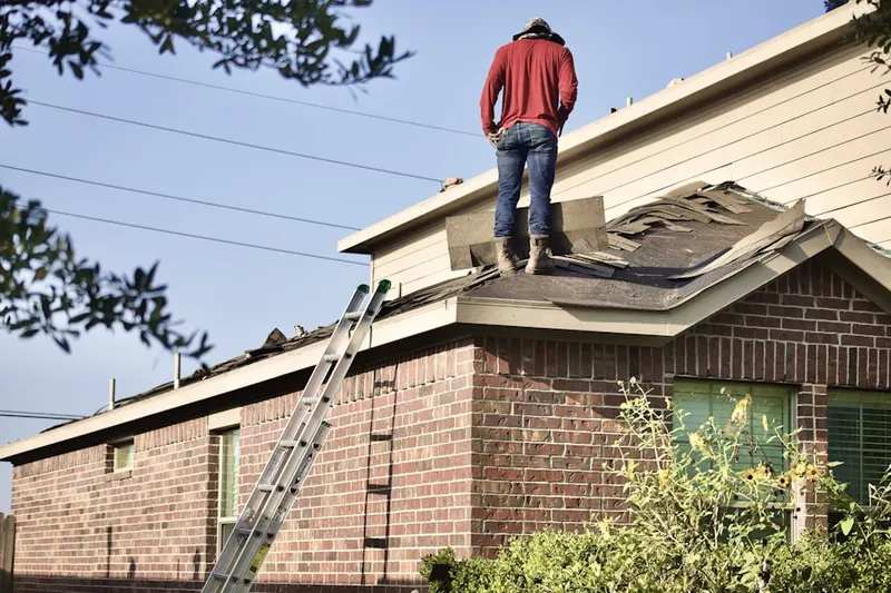Professional roofer working on a residential roof in Mattapan